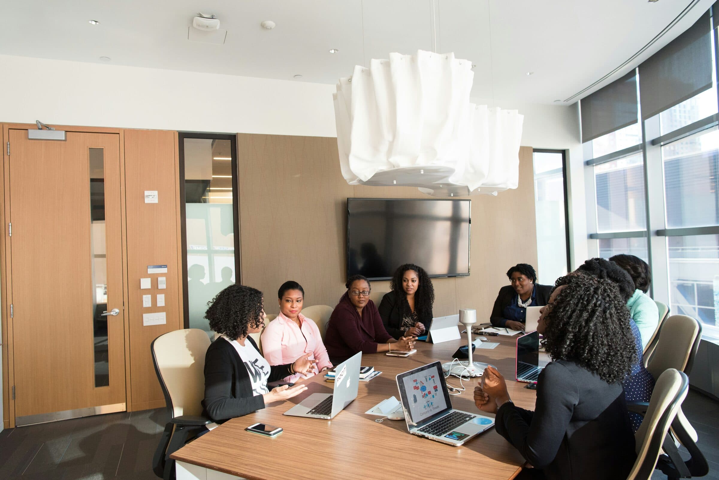 A group of professionals in discussion around a meeting table.